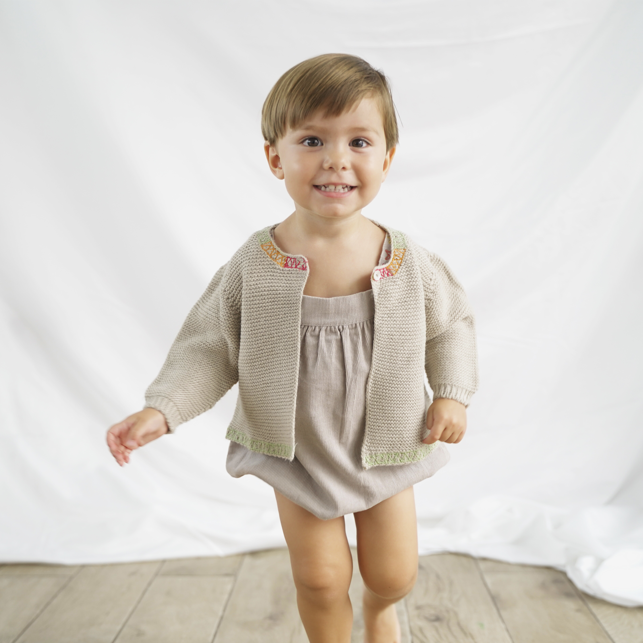 Toddler wearing a Piglo Kids cream knit sweater with colorful embroidered collar, perfect for baby boy and baby girl outfits.