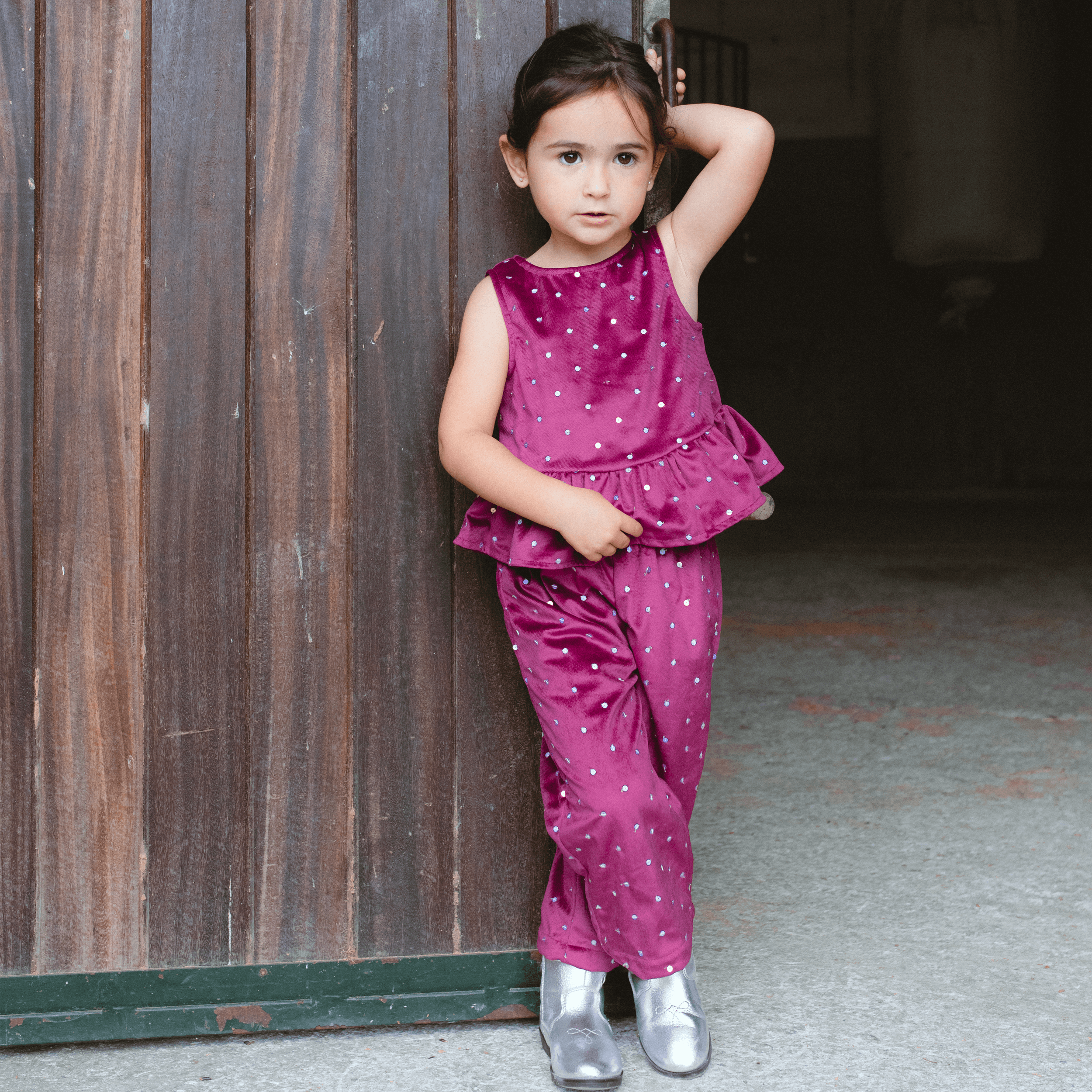 Girl wearing a red velvet top and pants set with sequins