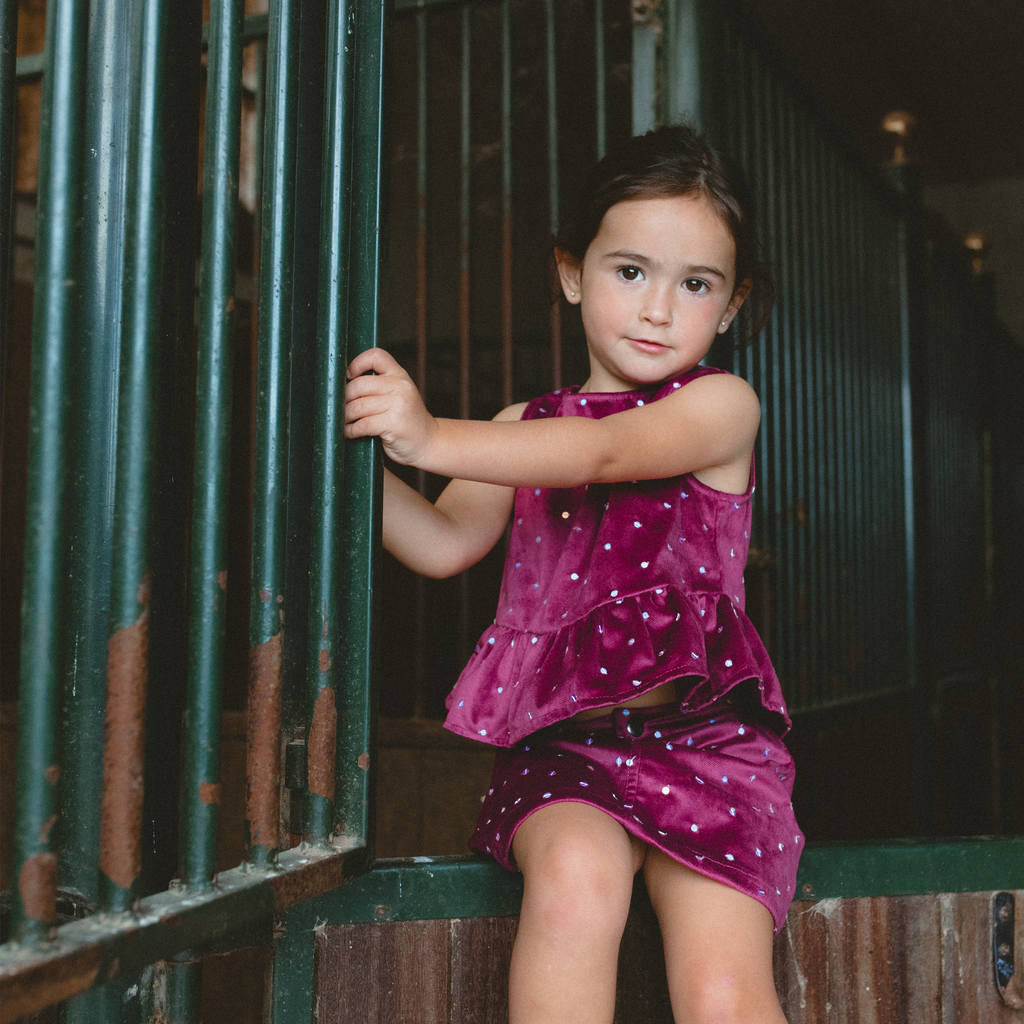 little girl dressing a  Piglo Kids red velvet top and skirt set.